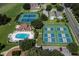 Aerial view of tennis and pickleball courts with green surroundings and nearby residential houses at 7034 Pine Hollow Dr, Mount Dora, FL 32757