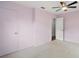 This bedroom includes a ceiling fan, neutral carpet, and light pink walls at 706 Michigan St, Mount Dora, FL 32757