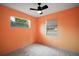 This bedroom includes two windows, neutral carpet, and orange walls at 706 Michigan St, Mount Dora, FL 32757