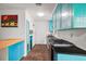Stylish kitchen featuring turquoise cabinetry, stainless steel appliances, and wood-look tile flooring at 706 Michigan St, Mount Dora, FL 32757