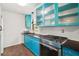Bright kitchen featuring custom turquoise cabinetry, stainless steel appliances, and modern design at 706 Michigan St, Mount Dora, FL 32757
