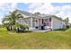Lush backyard featuring mature palm trees and a cozy screened-in porch at 767 Barbados Pl, The Villages, FL 32162