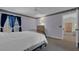 Comfortable bedroom featuring a black iron bed frame, blue curtains, and an ensuite bathroom at 767 Barbados Pl, The Villages, FL 32162