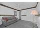 Neutral toned bedroom with light gray carpet, double closets, and a loveseat at 767 Barbados Pl, The Villages, FL 32162