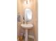 Powder room with modern pedestal sink, stylish mirror, and tasteful decor at 769 Daybreak Pl, Longwood, FL 32750