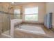 Elegant bathroom with glass-enclosed shower, soaking tub, and decorative tile accents at 769 Daybreak Pl, Longwood, FL 32750