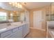 Bright bathroom featuring double sinks, large mirror, and a glass-enclosed shower with tile accents at 769 Daybreak Pl, Longwood, FL 32750