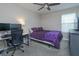 Comfortable bedroom setup with a purple bedspread, desk with computer monitors, and a large window at 769 Daybreak Pl, Longwood, FL 32750