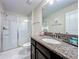 Bathroom with a granite countertop, large mirror, and glass shower at 9018 Stinger Dr, Davenport, FL 33896