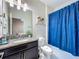 Bathroom featuring a shower with blue curtain, a mirror, and a granite countertop at 9018 Stinger Dr, Davenport, FL 33896