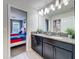 Bathroom with dual sinks, granite countertops, and a view of bedroom at 9018 Stinger Dr, Davenport, FL 33896