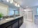 Elegant bathroom with a dual sink vanity, granite countertop, and glass-enclosed shower at 9018 Stinger Dr, Davenport, FL 33896