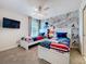 Fun bedroom with two beds, ceiling fan, and unique Mickey Mouse wall art at 9018 Stinger Dr, Davenport, FL 33896