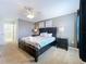 Cozy bedroom with a large bed, dark furniture, and neutral decor at 9018 Stinger Dr, Davenport, FL 33896