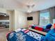 Bright bedroom features two twin beds, ceiling fan, and a TV at 9018 Stinger Dr, Davenport, FL 33896