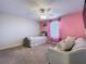 Charming bedroom with a princess-themed bed, pink walls, and a cozy loveseat at 9018 Stinger Dr, Davenport, FL 33896