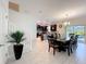 Dining area with seating for eight with views to the kitchen, stairs and access to a screen in porch at 9018 Stinger Dr, Davenport, FL 33896