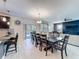 Open-concept dining area with seating for eight, connecting the kitchen, living room, and outdoor patio at 9018 Stinger Dr, Davenport, FL 33896