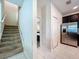 Hallway leading to a kitchen with stainless steel appliances and a staircase with carpeted steps at 9018 Stinger Dr, Davenport, FL 33896