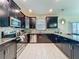 Well-lit kitchen showcasing stainless steel appliances, dark cabinetry, and stylish backsplash at 9018 Stinger Dr, Davenport, FL 33896