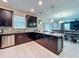 An open kitchen connects seamlessly to dining and living areas, featuring dark cabinets and granite counters at 9018 Stinger Dr, Davenport, FL 33896