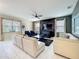 Bright living room with white tile flooring, dark accent wall, white sofas and lots of natural light at 9018 Stinger Dr, Davenport, FL 33896