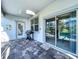 Covered patio with brick floors, grill, and sliding doors to the screened-in pool at 9018 Stinger Dr, Davenport, FL 33896