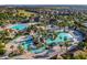 An inviting aerial shot displays a winding community pool surrounded by lush landscaping and comfortable seating at 9018 Stinger Dr, Davenport, FL 33896