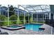 Beautiful screened-in pool and hot tub with paver patio and landscaped backyard at 9018 Stinger Dr, Davenport, FL 33896