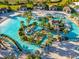 An aerial view showing the community's winding pool with water features, palm trees, and chairs for lounging at 9018 Stinger Dr, Davenport, FL 33896