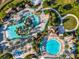 An aerial shot highlights various pools, sunbathing areas, and mature landscaping at the property at 9018 Stinger Dr, Davenport, FL 33896