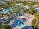 This aerial shot focuses on the community splash pad and pool, with palm trees and ample lounging at 9018 Stinger Dr, Davenport, FL 33896