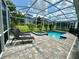 Relaxing lounge chairs on the patio by the screened-in pool and hot tub at 9018 Stinger Dr, Davenport, FL 33896