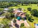 Aerial view of a property clubhouse featuring lush landscaping, circular drive and well-kept exterior at 9089 Saint Andrews Way, Mount Dora, FL 32757