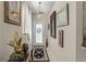 Warm, inviting hallway featuring decorative artwork, neutral paint, and an elegant overhead light fixture at 9089 Saint Andrews Way, Mount Dora, FL 32757