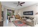 Cozy living room with neutral paint, ceiling fan, and tile flooring, connecting to an outdoor space at 9089 Saint Andrews Way, Mount Dora, FL 32757