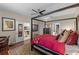 Spacious main bedroom featuring a four-poster bed, ceiling fan, and multiple entryways at 9089 Saint Andrews Way, Mount Dora, FL 32757