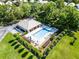 Aerial view of a community pool and lounge area with mature landscaping and bright sunny skies at 9089 Saint Andrews Way, Mount Dora, FL 32757