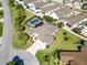 Aerial view of a well-manicured property with a screened-in pool and lush green surroundings at 973 Baisley Trl, The Villages, FL 32162