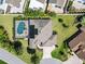 Aerial shot of a private home with a screened-in pool and meticulously landscaped yard at 973 Baisley Trl, The Villages, FL 32162