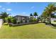 A well-maintained backyard with a manicured lawn and lush tropical landscaping at 973 Baisley Trl, The Villages, FL 32162