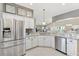 Kitchen with stainless steel refrigerator and granite countertops and white cabinets at 973 Baisley Trl, The Villages, FL 32162