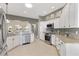 Bright kitchen featuring stainless steel appliances, white cabinetry, and granite countertops at 973 Baisley Trl, The Villages, FL 32162