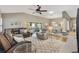 Spacious living room with a ceiling fan, wood floors, a dining area, and lots of seating at 973 Baisley Trl, The Villages, FL 32162