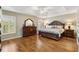 Main bedroom featuring wood floors, tray ceiling, and shuttered windows at 973 Baisley Trl, The Villages, FL 32162