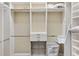 Walk-in closet features built-in shelving and drawers for organization at 973 Baisley Trl, The Villages, FL 32162