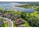 Aerial view of waterfront community featuring mature trees, manicured lawns, and picturesque lakeside scenery at 10069 Lake Miona Way, Oxford, FL 34484