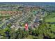 Aerial view of a home in a community near a lake, surrounded by lush green trees and manicured lawns at 10069 Lake Miona Way, Oxford, FL 34484