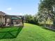 Backyard with a screened-in patio, offers ample space for outdoor activities, and enjoyment at 10069 Lake Miona Way, Oxford, FL 34484