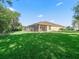 This property has a beautiful backyard, showcasing the screened-in patio, and ample lawn space at 10069 Lake Miona Way, Oxford, FL 34484